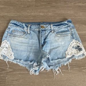 Blue jean shorts with white flower side.